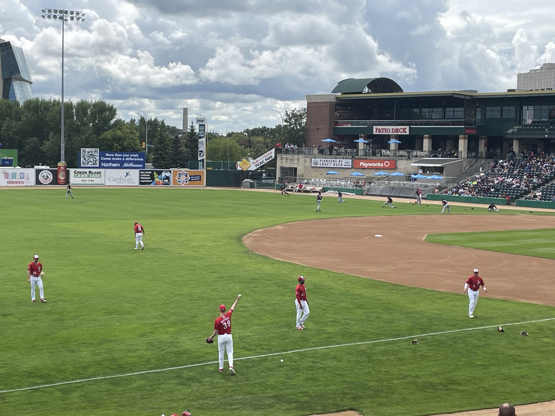 Baseball team in red shirts/white pants on a baseball diamon warming up to play