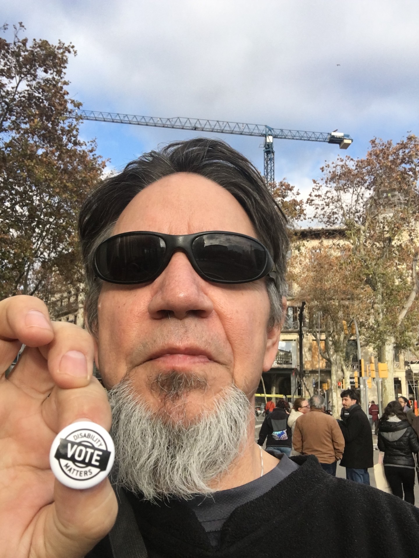 Patrick Falconer holding a Disability Votes Matter Pin