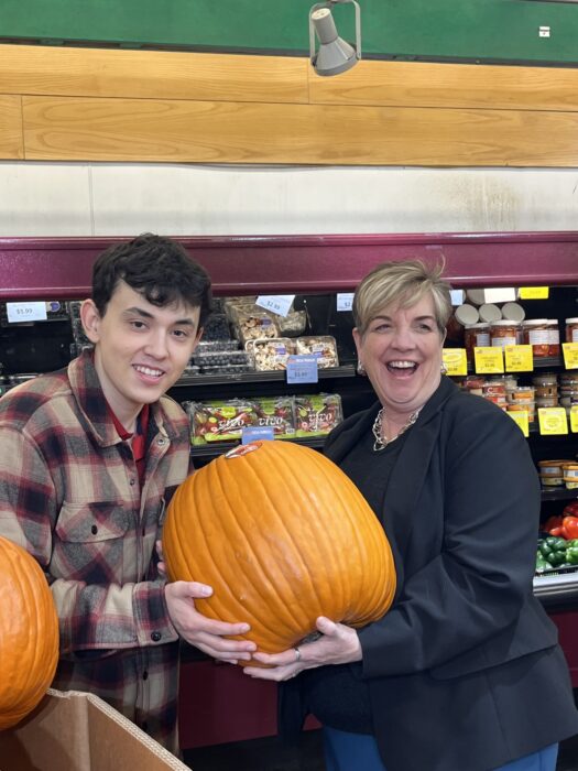 Minister Naylor and Robert holding a pumpkin at FoodFare